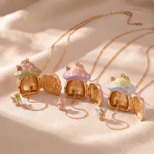 Nahaufnahme von offenen Makronen-Pilzhaus-Medaillons mit kleinen Feen und goldenen Ketten