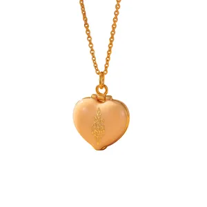 Detailed view of peach enamel heart locket with delicate gold flower engraving