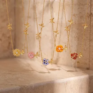 Collection of copper birth flower necklaces with colorful enamel and gold butterflies