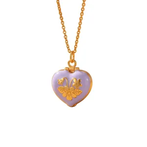 Close-up of a vintage-style purple enamel heart locket with gold floral patterns