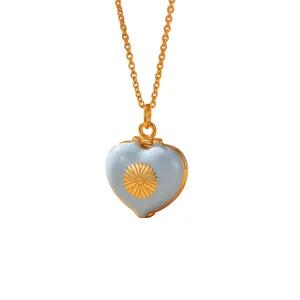 Detailed view of light blue enamel heart locket featuring a golden daisy motif