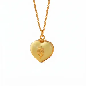 Detail of golden heart locket necklace with cream enamel and narcissus engraving.