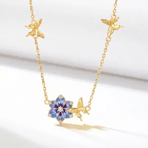 Detail view of a gold-tone December birth flower necklace with enamel pendant and butterflies