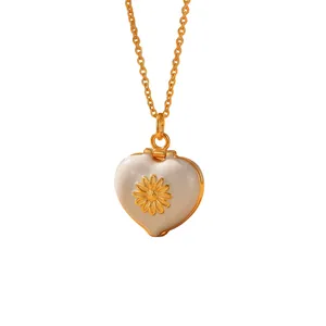 Elegant close-up of a golden heart locket necklace with enamel daisy flower design