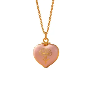 Macro view of pink heart enamel locket featuring a gold carnation flower engraving