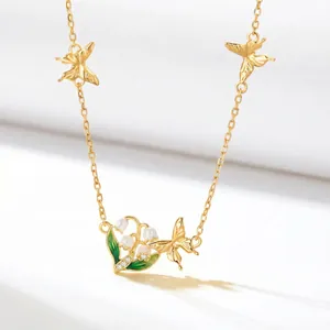 Detailed view of elegant gold-plated necklace featuring butterfly and lily of the valley
