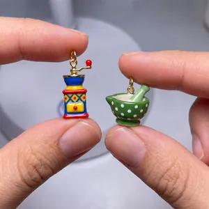 Detailed view of miniature colorful enameled coffee mill and mortar pestle charms