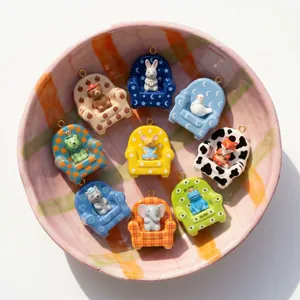 Detailed macro view of cute cartoon animal pendants sitting in miniature armchairs.