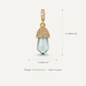 Detailed macro view of a crystal acorn pendant with 14K gold plated copper and zircon.