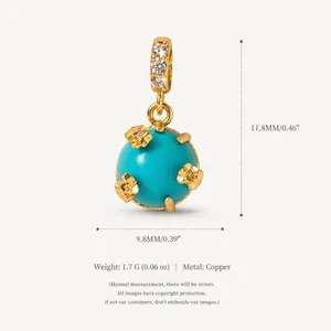 Close-up of a decorative turquoise style ball pendant with gold flowers and zircon bail.