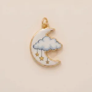 Macro detail of a delicate gold-tone crescent moon and cloud enamel pendant for DIY jewelry