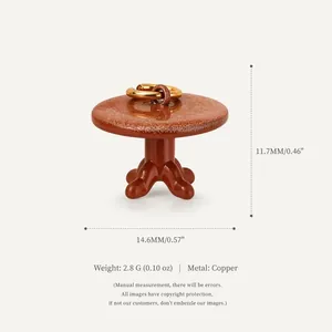 Close-up of a miniature copper table charm with dimensions and weight specs