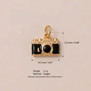 Detailed view of a gold and black camera-shaped copper pendant with dimensions