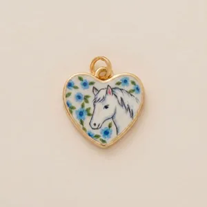 Detailed view of gold-framed heart pendant featuring a hand-painted white horse and blue flowers