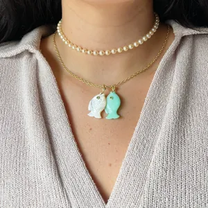 Detailed close-up of colorful fish pendants on a delicate gold chain necklace