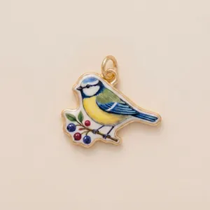 Detailed macro shot of a colorful enamel blue tit bird pendant charm for DIY jewelry craft