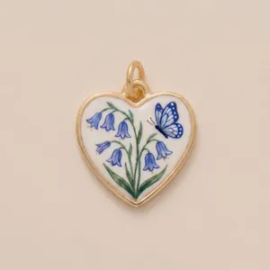 Detailed macro shot of heart-shaped gold pendant with bluebells and butterfly design