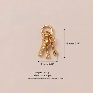 Close-up of mini golden copper key charms showing size measurements and details