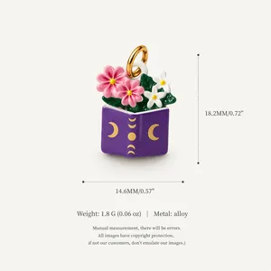 Enamel flower and purple book charm with moon symbols and 18K gold plating detail.