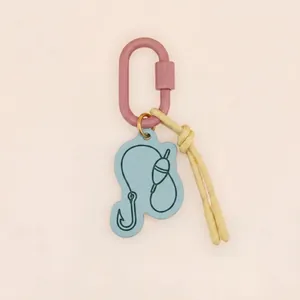 Détail d'un porte-clés de camping en acrylique bleu avec motif hameçon et mousqueton rose