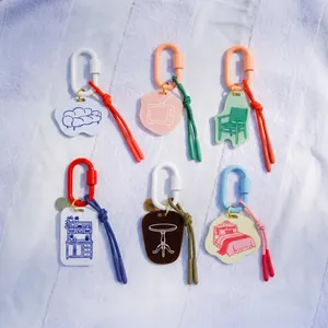 Group of minimalist acrylic keychains featuring furniture icons and colorful carabiners.