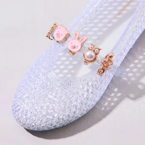 Detailaufnahme süßer Tier-Schuhclips mit Kunstperlen auf transparenten Netzschuhen