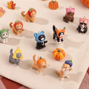 Group display of adorable miniature cat charms wearing various fruit and vegetable hats.