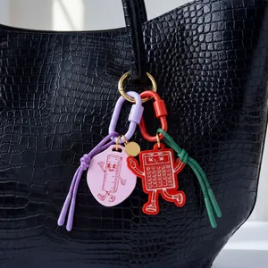 Primo piano di ciondoli per borsa in acrilico con righello e calcolatrice su borsa nera