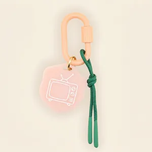 Close-up of retro TV charm keychain with pink carabiner and green rope strap