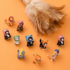 Detail view of miniature ceramic cat charms wearing colorful fruit and vegetable hats