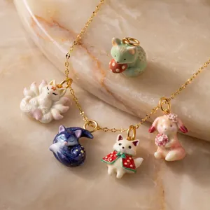 Macro view of dreamy porcelain nine-tailed fox and animal charms on a gold chain necklace