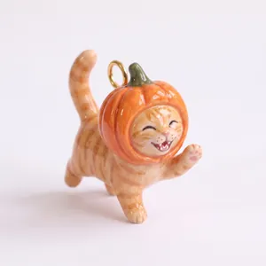 Detailed view of cute ceramic tabby cat charm wearing a pumpkin hat for DIY jewelry making