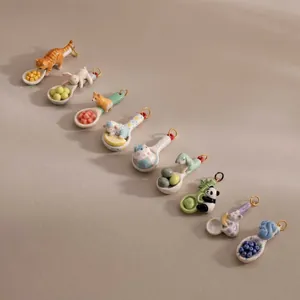 Vista dettagliata di vari ciondoli a cucchiaio con animali in ceramica per gioielli fai da te.