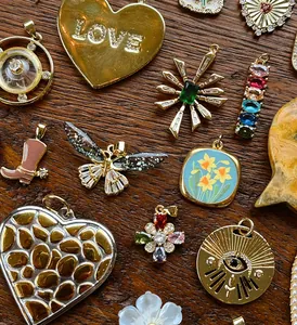 Primo piano di vari ciondoli gioielli vintage fatti a mano su fondo in legno