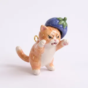Detailed view of a cute angry ginger cat pendant wearing a blue fruit hat for DIY jewelry