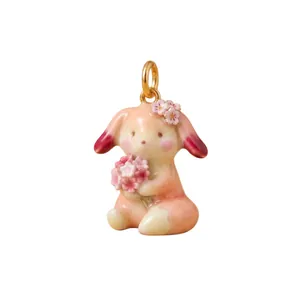 Detailed macro view of a cute enamel lop-eared rabbit pendant holding a bunch of pink flowers