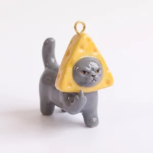 Detailed view of a funny grey cat ceramic charm wearing a cheese hat for DIY jewelry