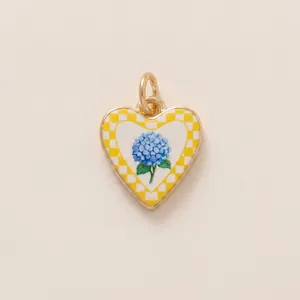Detail view of heart-shaped pendant featuring a blue hydrangea and yellow checkered pattern