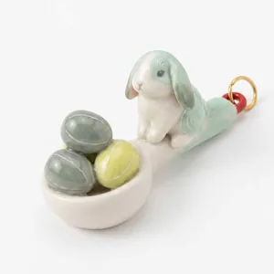 Dettaglio di un ciondolo a mini cucchiaio in ceramica con coniglio e uovo di Pasqua