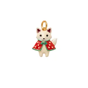 Detailed macro shot of a cute fox jewelry pendant wearing a red cloak and green bow