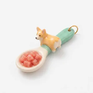 Vista dettagliata di un ciondolo mini cucchiaio creativo con un corgi 3D e pezzi di frutta