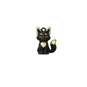Close-up detail of a cute black fox pendant charm featuring amber eyes and creamy accents