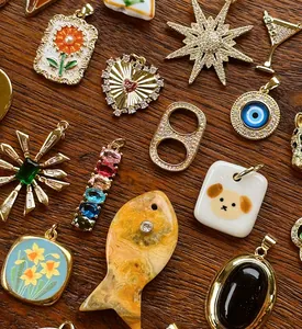 Primo piano di vari ciondoli fatti a mano in stile vintage con stelle, cuori e motivi floreali
