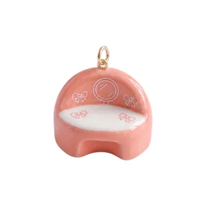 Dettaglio di un ciondolo divano da toeletta macaron rosa con finitura in smalto