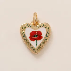 Macro view of heart-shaped gold-plated pendant with red poppy flower and vine border