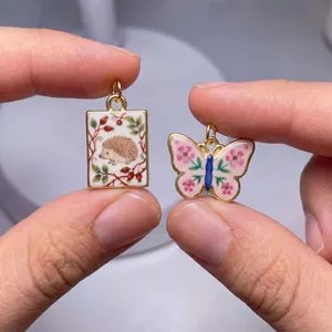 Detailed macro view of vintage hand-painted hedgehog and butterfly charms for DIY jewelry