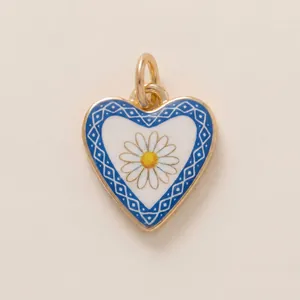 Detailed close-up of a heart-shaped blue enamel pendant featuring a white daisy design