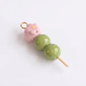 Vue détaillée d'un pendentif dango en émail 3D de couleurs rose pastel et vert