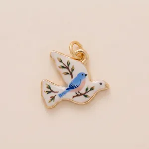 Detail of retro painted bird pendant with blue bird and branch design for DIY jewelry