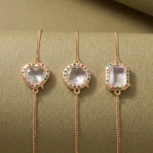 Close-up showing the detail of heart, round, and rectangular rainbow crystal gold bracelets.